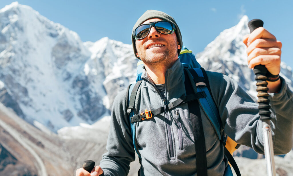 Uomo in montagna con lenti per sciatori